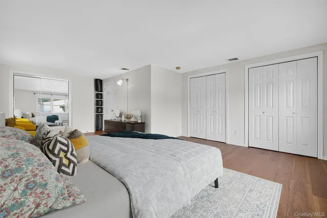 a large bedroom with a bed and wooden floor