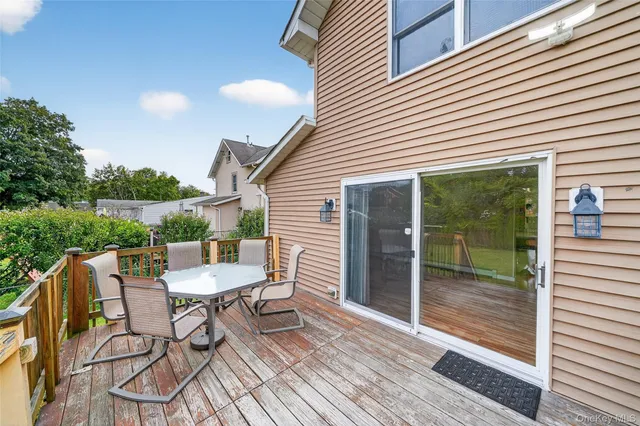 a balcony with table and chairs and potted plants