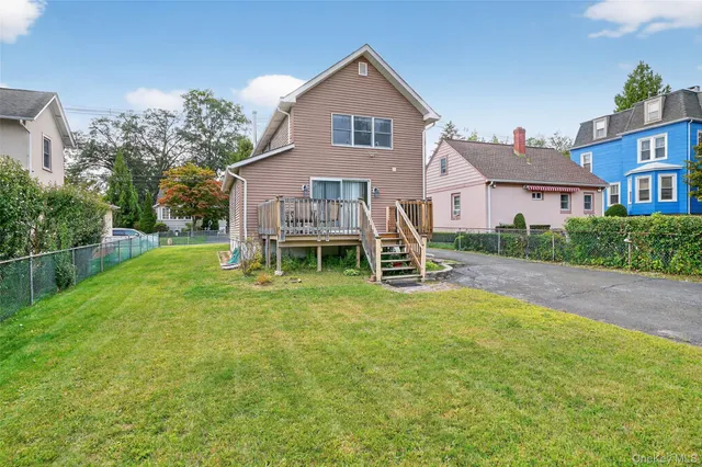 a front view of a house with a yard and trees