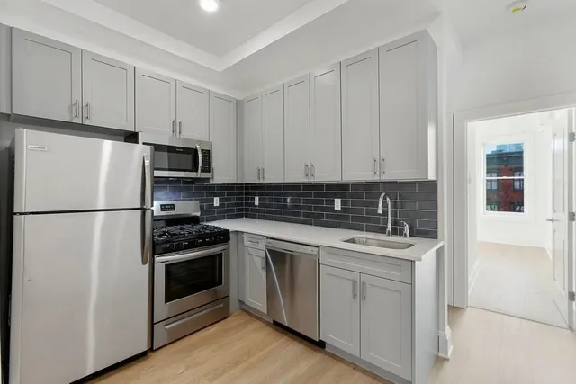 a kitchen with cabinets stainless steel appliances and sink