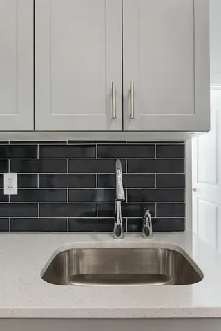 a view closed with granite countertop a sink and white cabinets