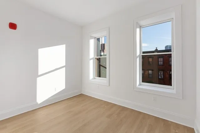an empty room with windows and closet