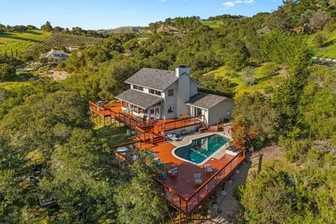 a view of a house with brick walls and a yard with plants