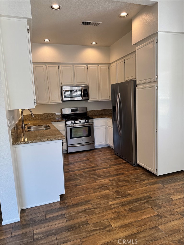 125 Pasto Rico Rancho Santa Margarita, CA 92688 - Photo 6 of 14 a kitchen with stainless steel appliances granite countertop a refrigerator stove and wooden floor