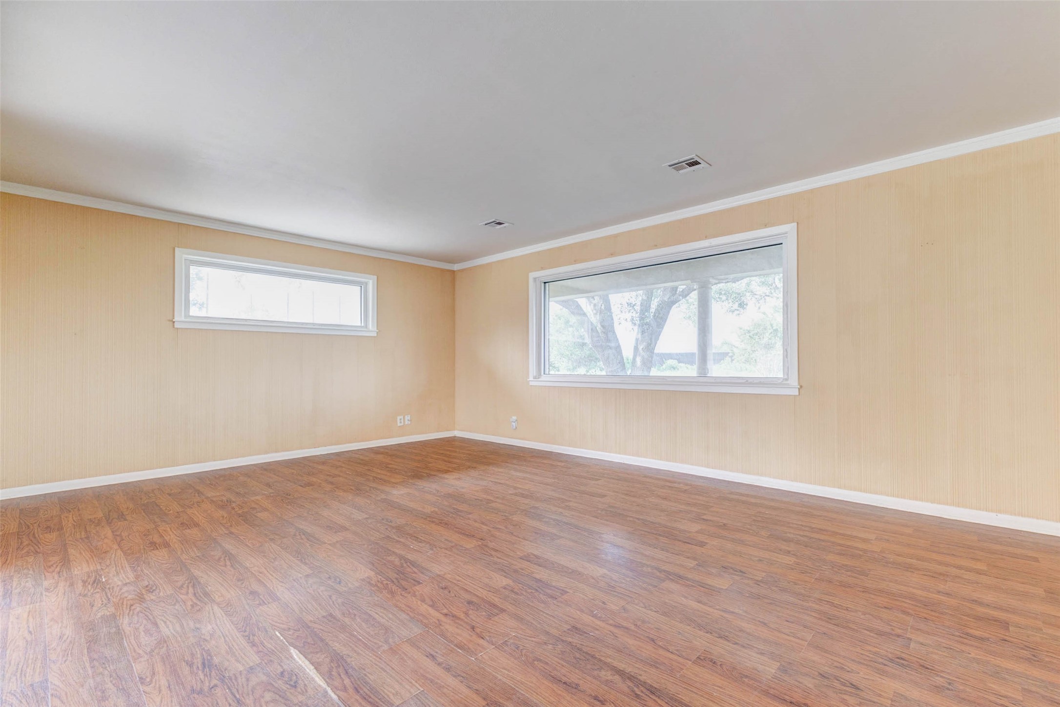 925 Norcross Road Wallis, TX 77485 - Photo 7 of 46 The spacious family room offers wood flooring, soft neutral tones, and oversized windows fill the room with abundant natural light while showcasing peaceful views of the surrounding acreage.