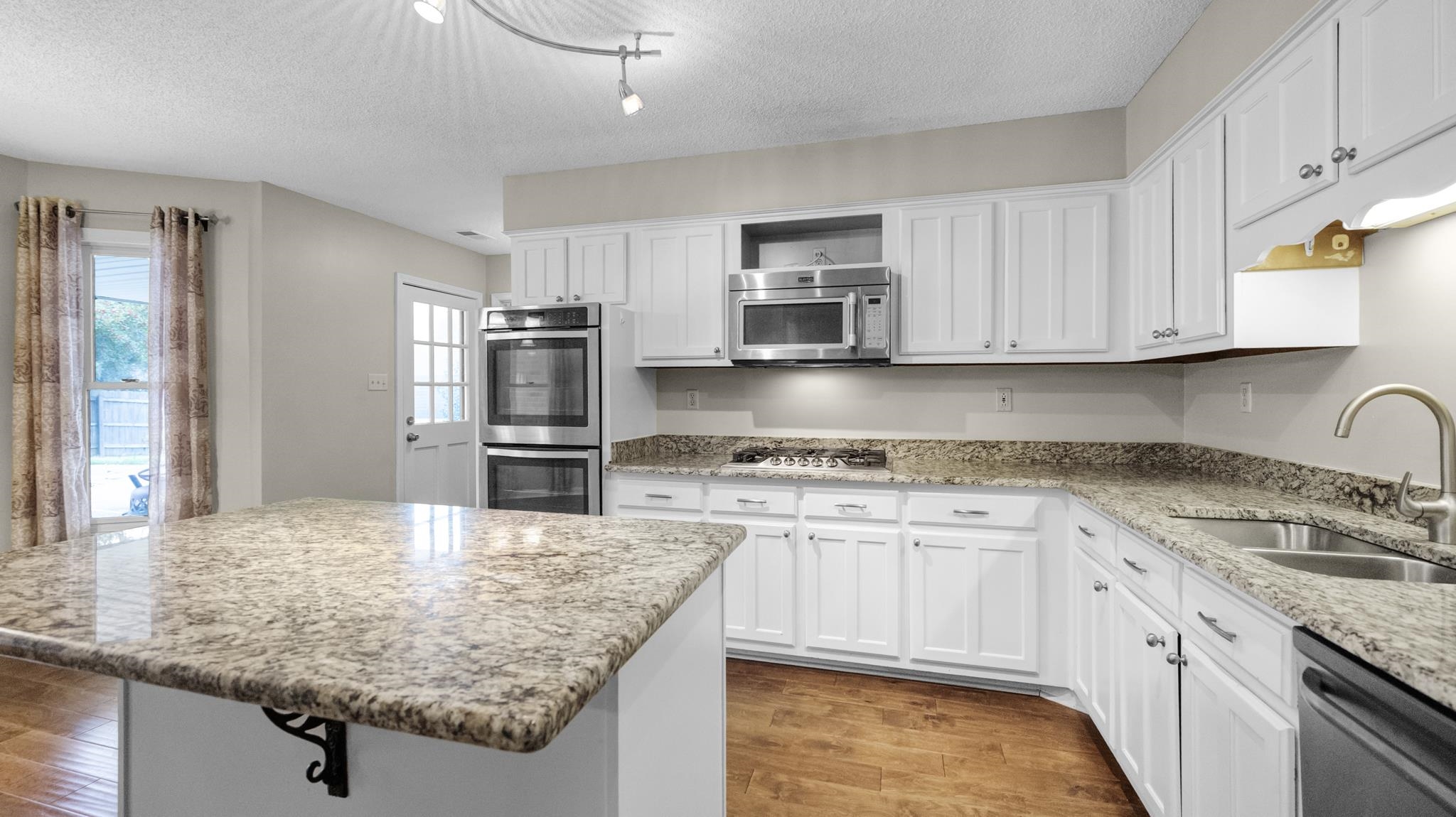 1105 Winrose Drive Collierville, TN 38017 - Photo 13 of 37 a kitchen with kitchen island granite countertop a sink stove and refrigerator