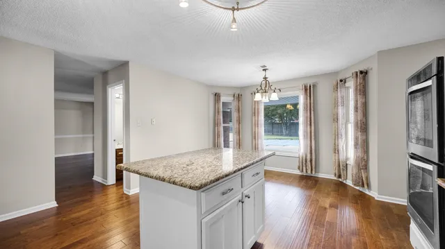 a kitchen with stainless steel appliances granite countertop a refrigerator a sink and a stove