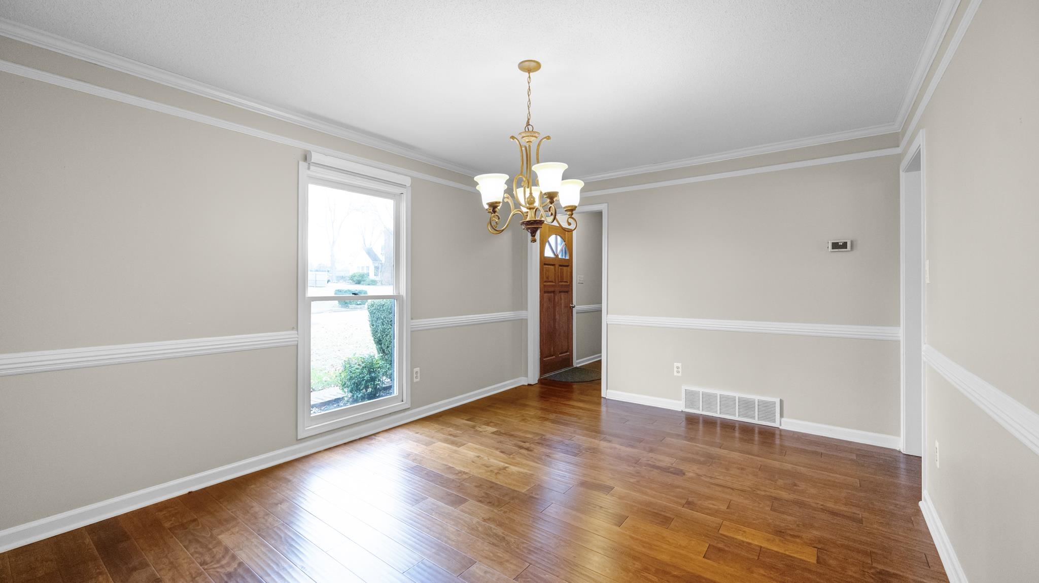 1105 Winrose Drive Collierville, TN 38017 - Photo 4 of 37 an empty room with wooden floor chandelier and windows