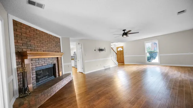 a view of empty room with wooden floor and fireplace