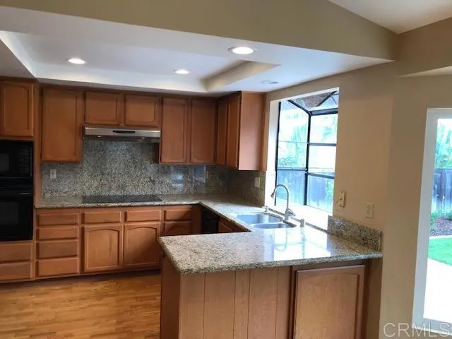 a kitchen with stainless steel appliances granite countertop a sink a counter space and cabinets