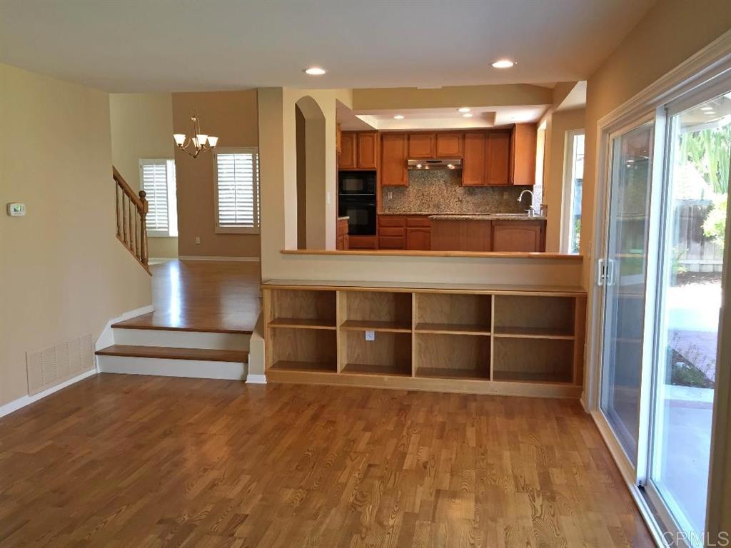 1917 Wandering Road Encinitas, CA 92024 - Photo 16 of 24 a view of a hallway with wooden floor and chandelier