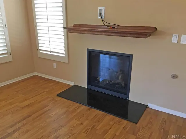 a view of a hallway with wooden floor and a fireplace