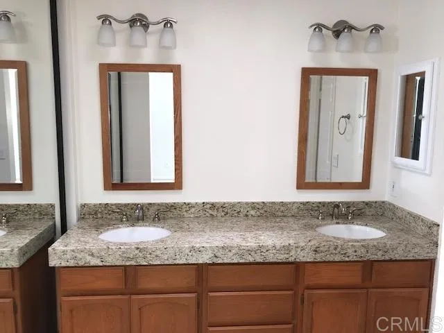 a bathroom with a granite countertop sink and a mirror