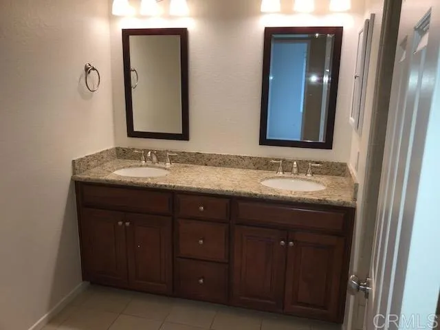 a bathroom with a double vanity sink and a mirror