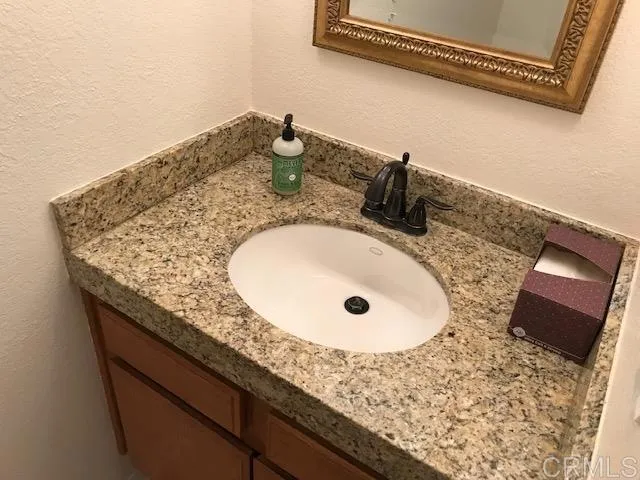 a bathroom with a granite countertop sink and mirror