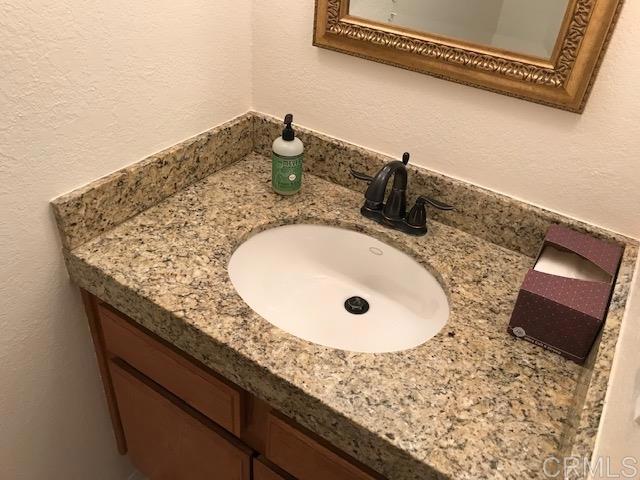 1917 Wandering Road Encinitas, CA 92024 - Photo 23 of 24 a bathroom with a granite countertop sink and mirror