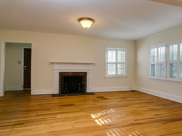 209 Avon Drive Raleigh, NC 27608 - Photo 3 of 20 Great size living room with fireplace and plantation shutters.