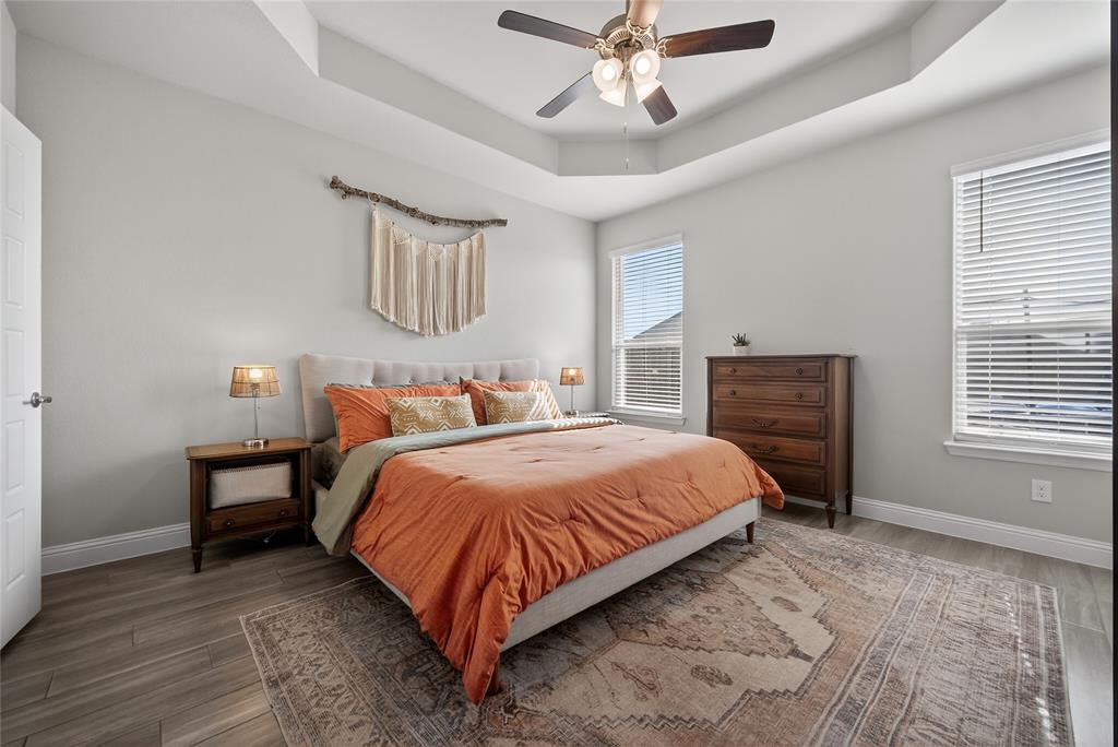 2252 Knightsgate Road Argyle, TX 76226 - Photo 15 of 36 Bedroom featuring a tray ceiling, wood finished floors, and a ceiling fan