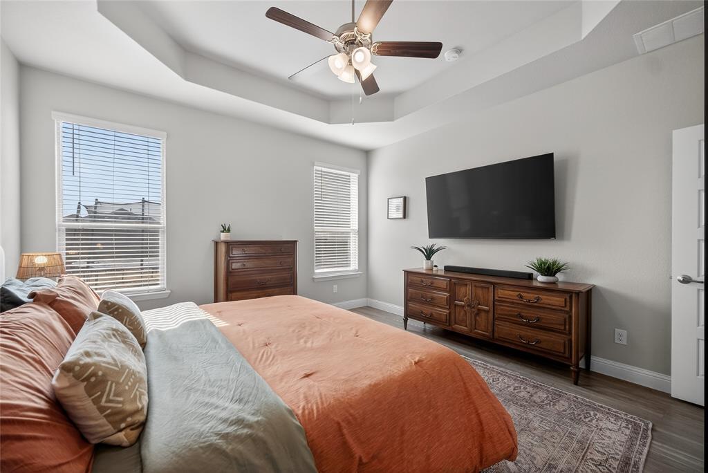 2252 Knightsgate Road Argyle, TX 76226 - Photo 17 of 36 Bedroom with a raised ceiling, wood finished floors, multiple windows, and a ceiling fan