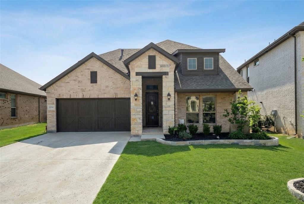 2252 Knightsgate Road Argyle, TX 76226 - Photo 2 of 36 View of front of house with roof with shingles, a front lawn, stone siding, and concrete driveway