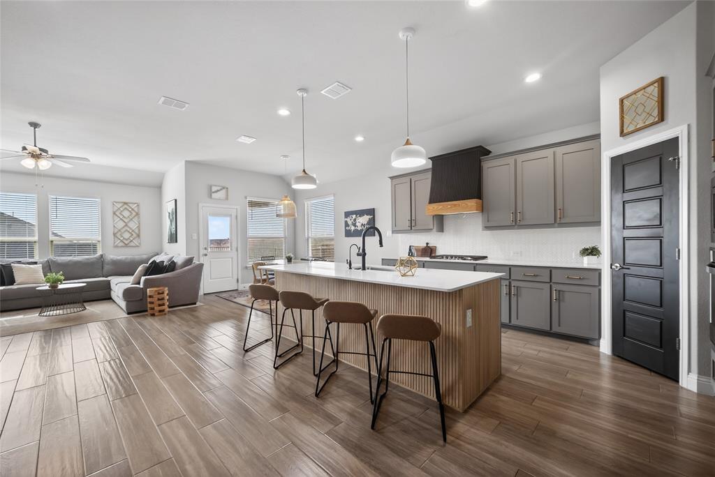 2252 Knightsgate Road Argyle, TX 76226 - Photo 36 of 36 Kitchen featuring a breakfast bar area, hanging light fixtures, a center island with sink, gray cabinetry, and open floor plan