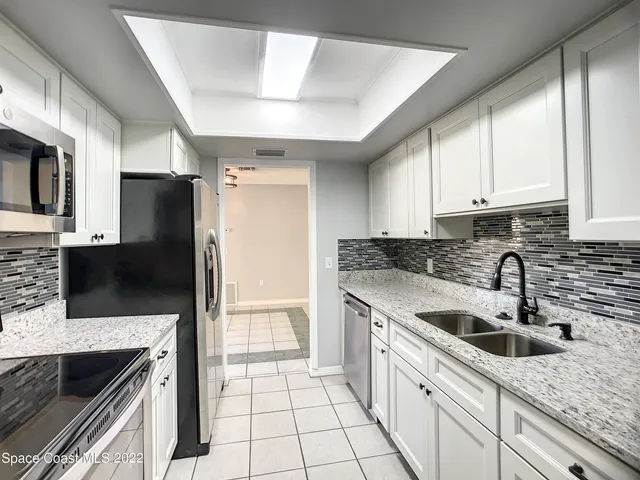 a kitchen with a sink a refrigerator and cabinets