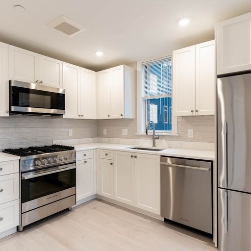 197 Green Street, Unit 305 Boston, MA 02130 - Photo 3 of 7 a kitchen with granite countertop white cabinets and stainless steel appliances