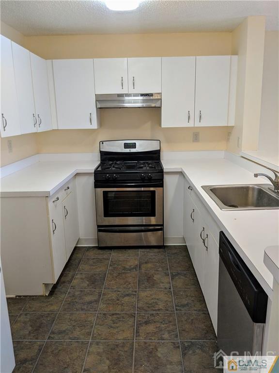 1223 Edpas Road, Unit 1223 New Brunswick, NJ 08901 - Photo 15 of 18 a kitchen with a stove and white cabinets