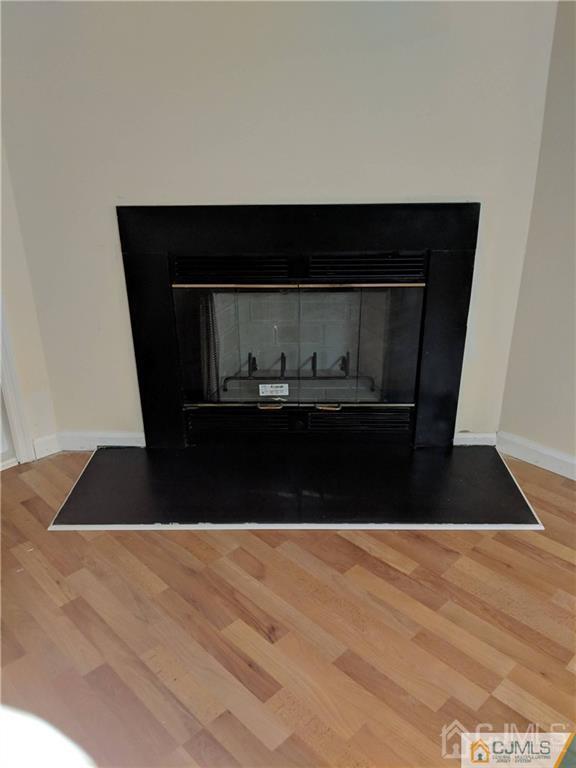1223 Edpas Road, Unit 1223 New Brunswick, NJ 08901 - Photo 4 of 18 a living room with a wooden floor and a fireplace
