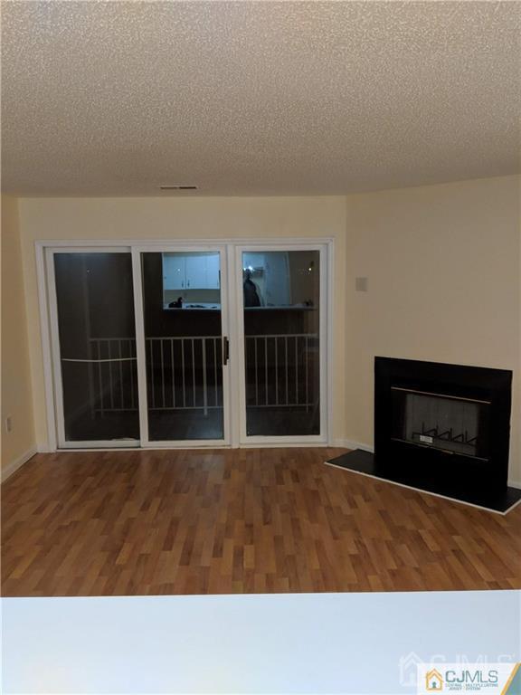 1223 Edpas Road, Unit 1223 New Brunswick, NJ 08901 - Photo 5 of 18 a living room with a fireplace and a flat screen tv