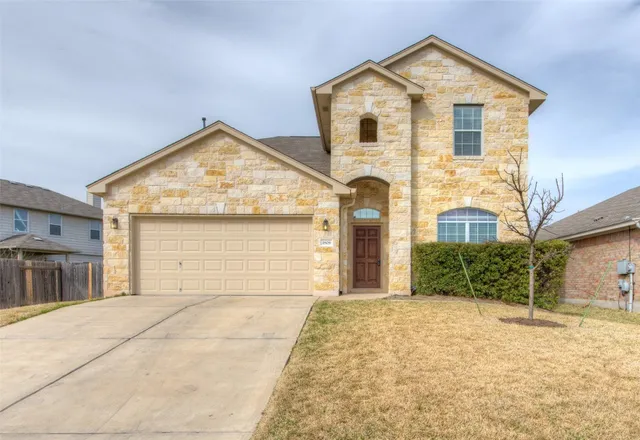 a front view of a house with a yard and garage