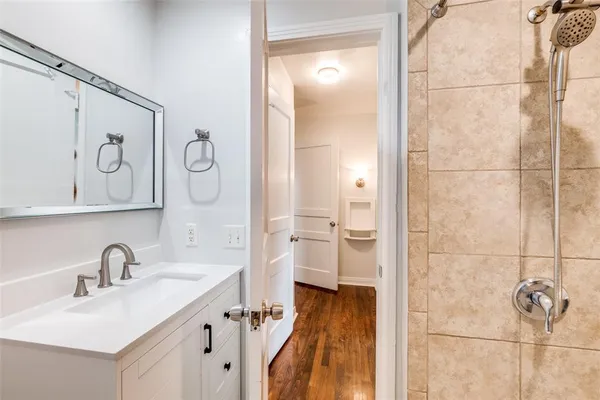 a bathroom with a sink and mirror with bathtub