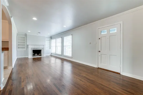 an empty room with wooden floor and fireplace