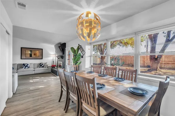 a view of a dining room with furniture a chandelier and wooden floor