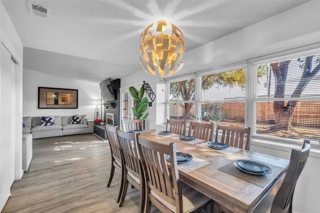 a view of a dining room with furniture a chandelier and wooden floor