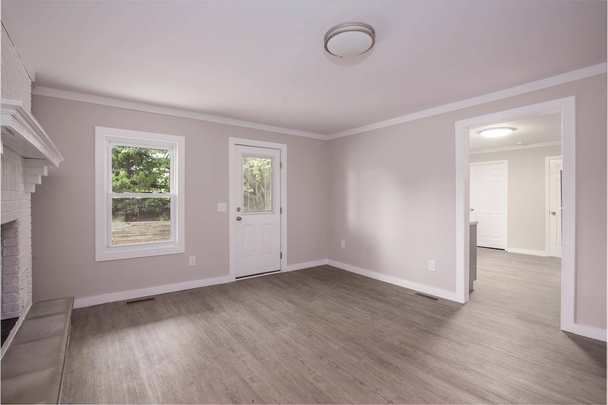 314 Depot Street Roxboro, NC 27573 - Photo 3 of 35 an empty room with wooden floor and windows