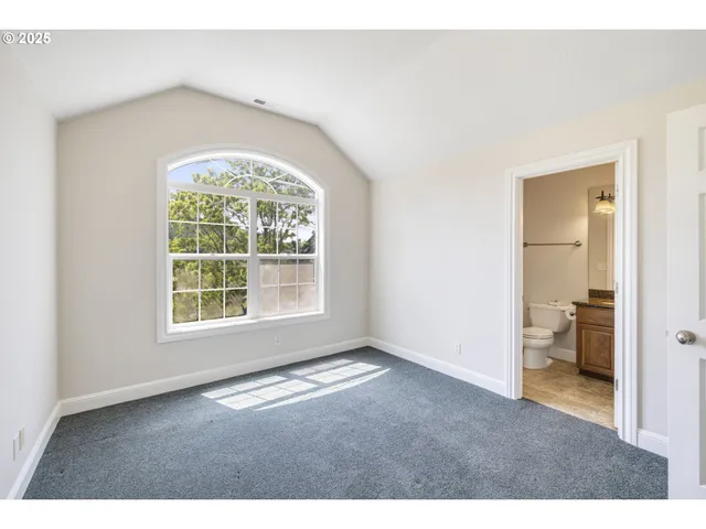 an empty room with a bathroom and a window