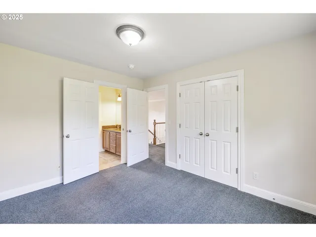a bathroom with a granite countertop double vanity and a mirror