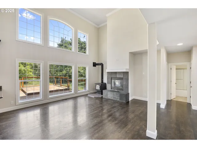 a view of empty room with wooden floor and fireplace