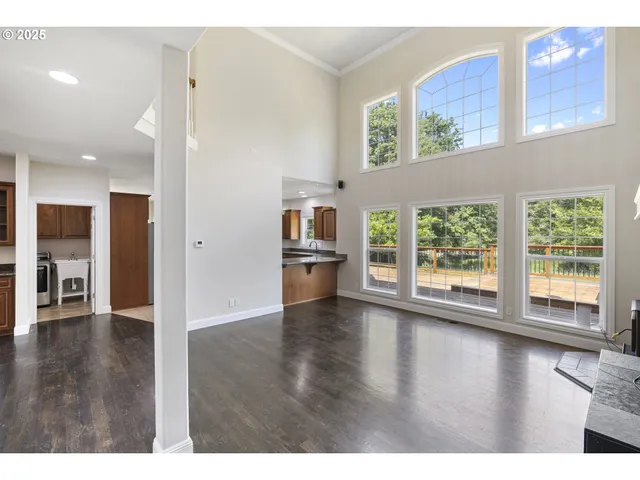 a view of a big room with wooden floor and windows