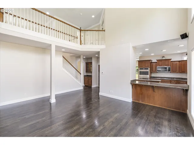 a view of kitchen with kitchen island wooden floor and stainless steel appliances