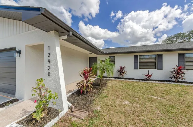 a view of a house with backyard and sitting area