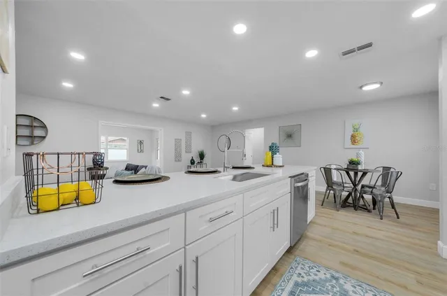 a kitchen with a sink and chairs with wooden floor