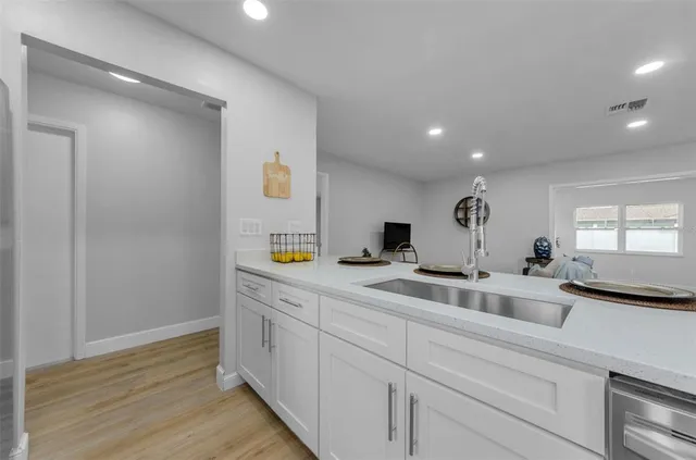 a kitchen with a sink and wooden floor