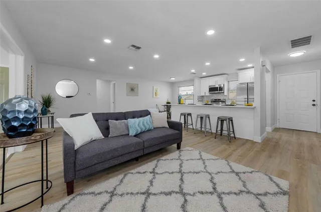 a living room with a couch and a view of kitchen