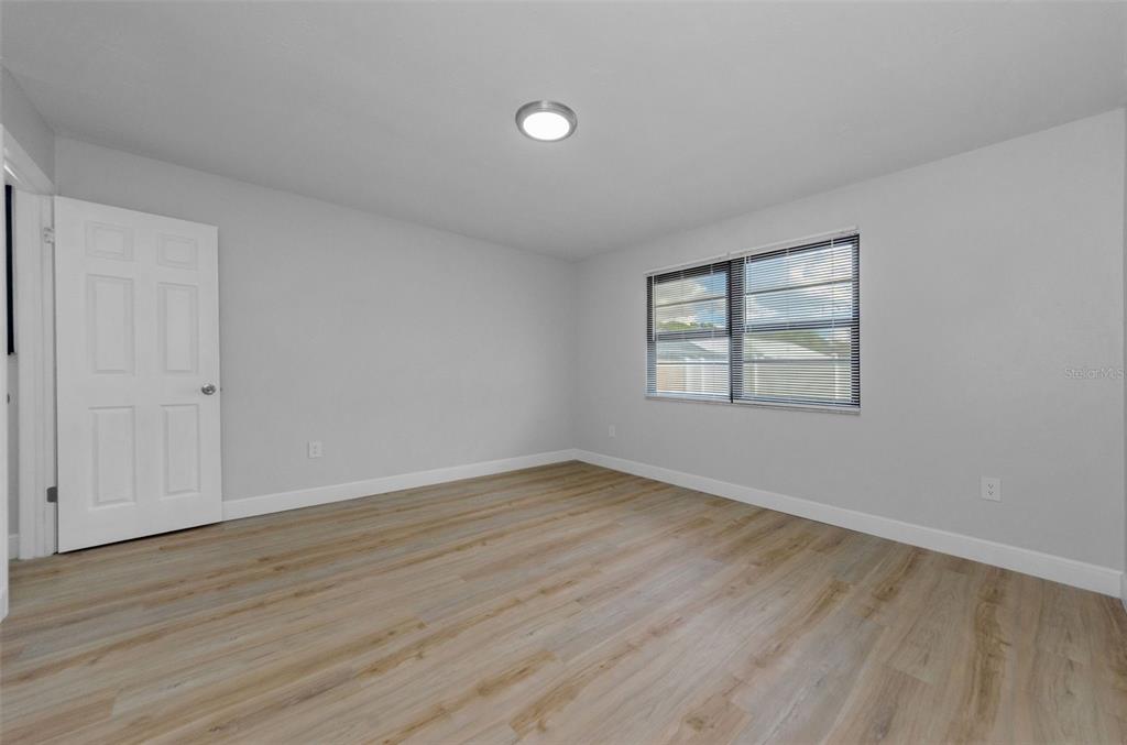 12920 Walnut Tree Lane Hudson, FL 34669 - Photo 21 of 35 an empty room with wooden floor and windows