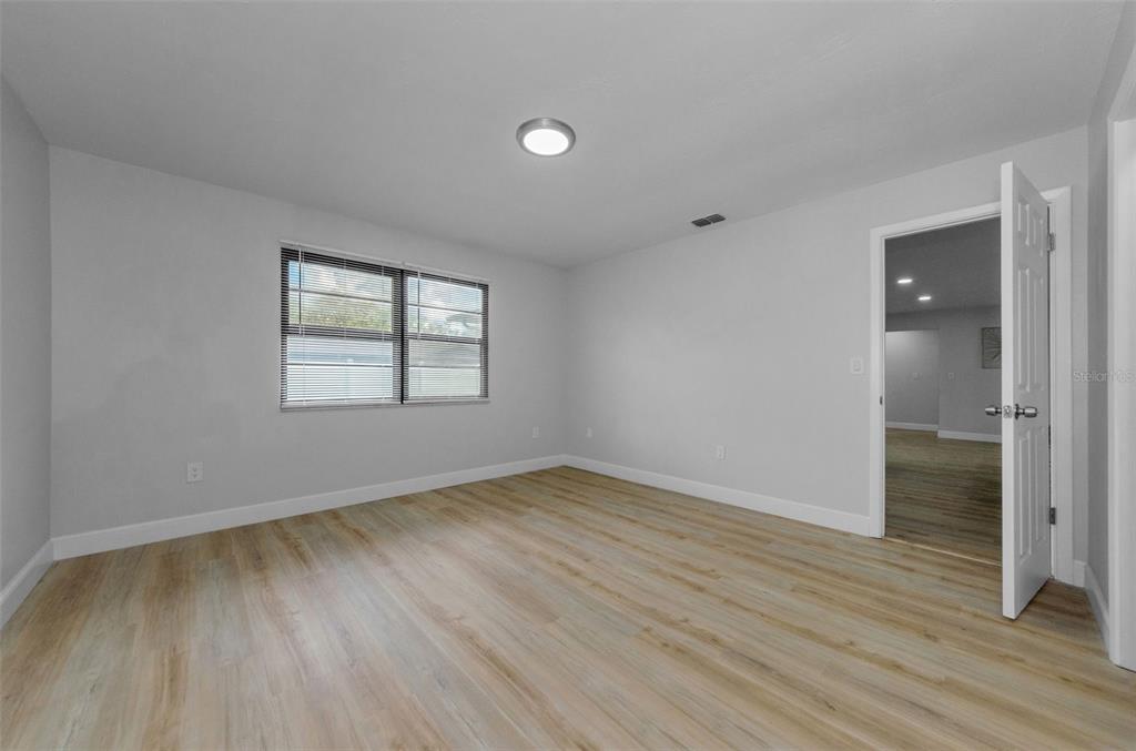 12920 Walnut Tree Lane Hudson, FL 34669 - Photo 22 of 35 an empty room with wooden floor and windows