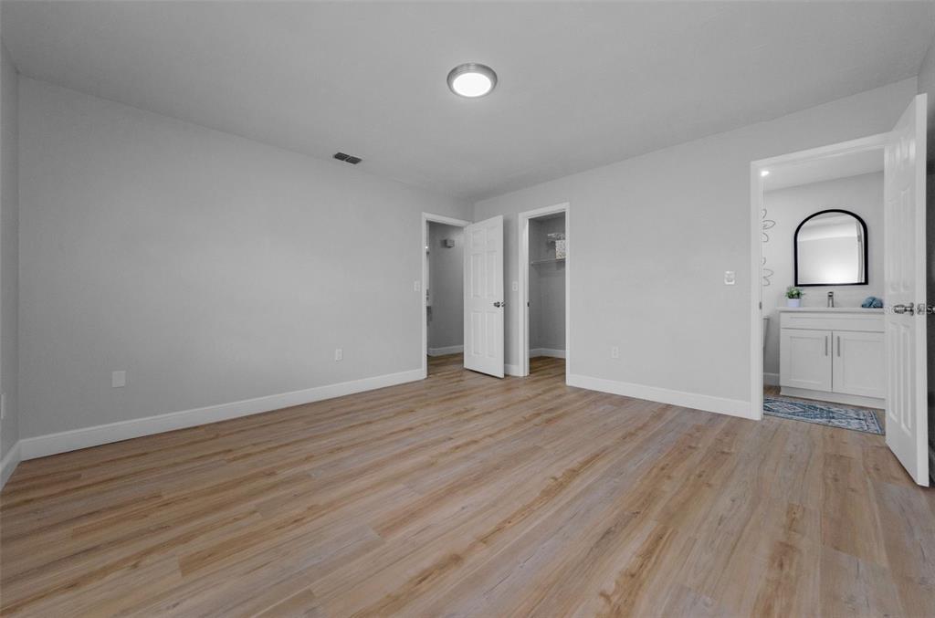 12920 Walnut Tree Lane Hudson, FL 34669 - Photo 23 of 35 an empty room with wooden floor and mirror