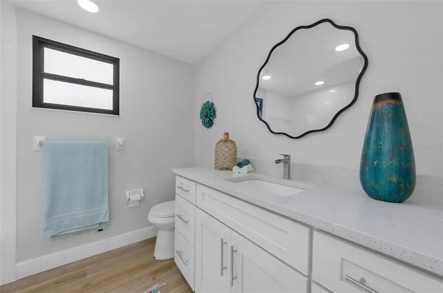 a bathroom with a sink a toilet and a mirror