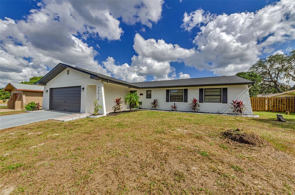 12920 Walnut Tree Lane Hudson, FL 34669 - Photo 5 of 35 a front view of a house with a garden